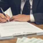 Lawyer signing contract - Buying a property in Spain